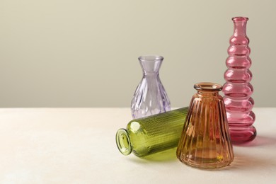 Photo of Different beautiful glass vases on white table against light grey background, space for text