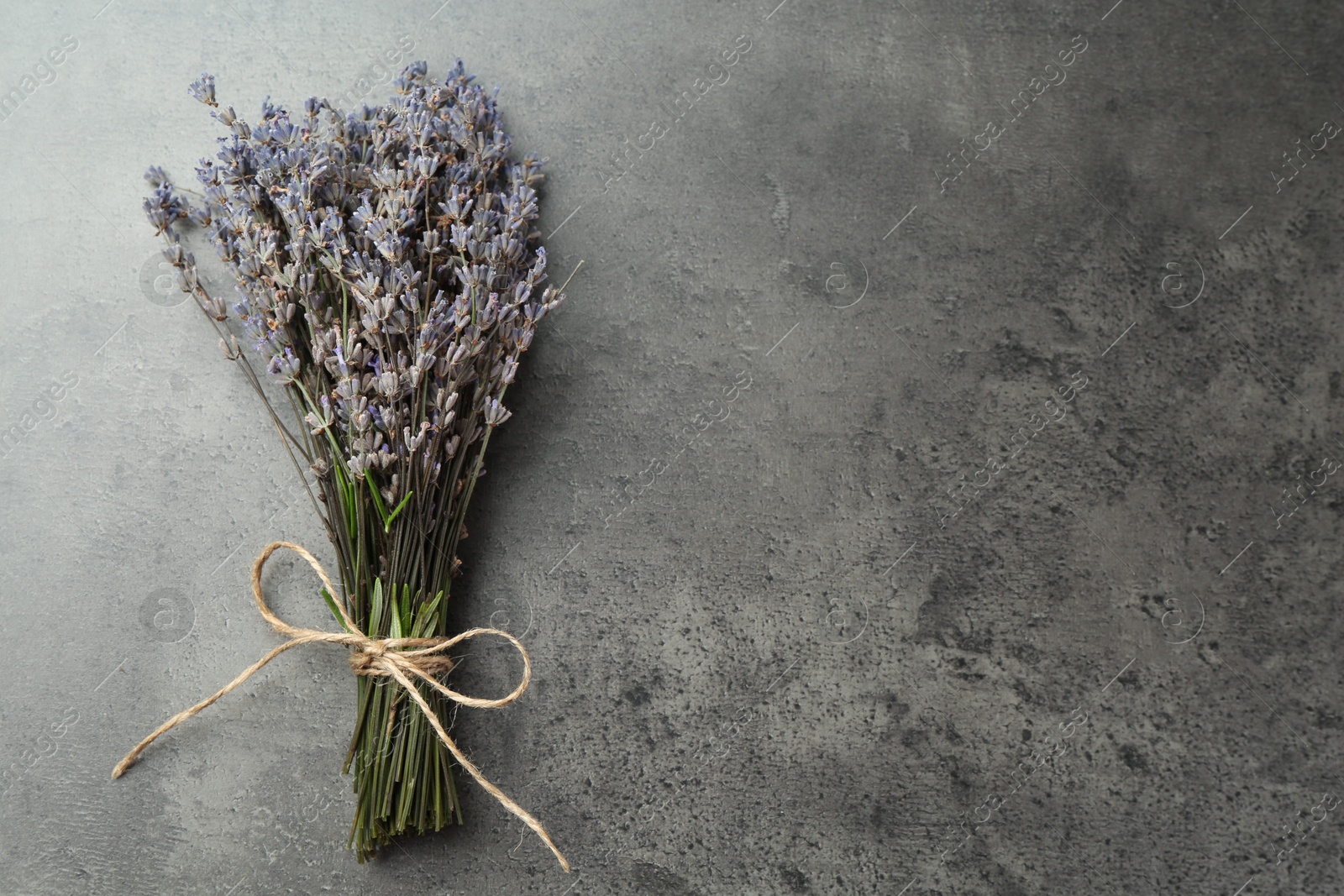 Photo of Bunch of fragrant lavender flowers on grey table, top view. Space for text