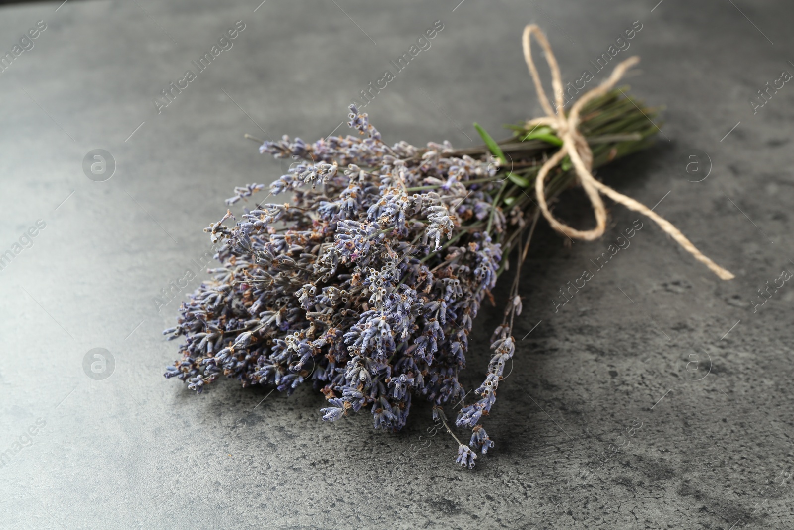 Photo of Bunch of fragrant lavender flowers on grey table, closeup