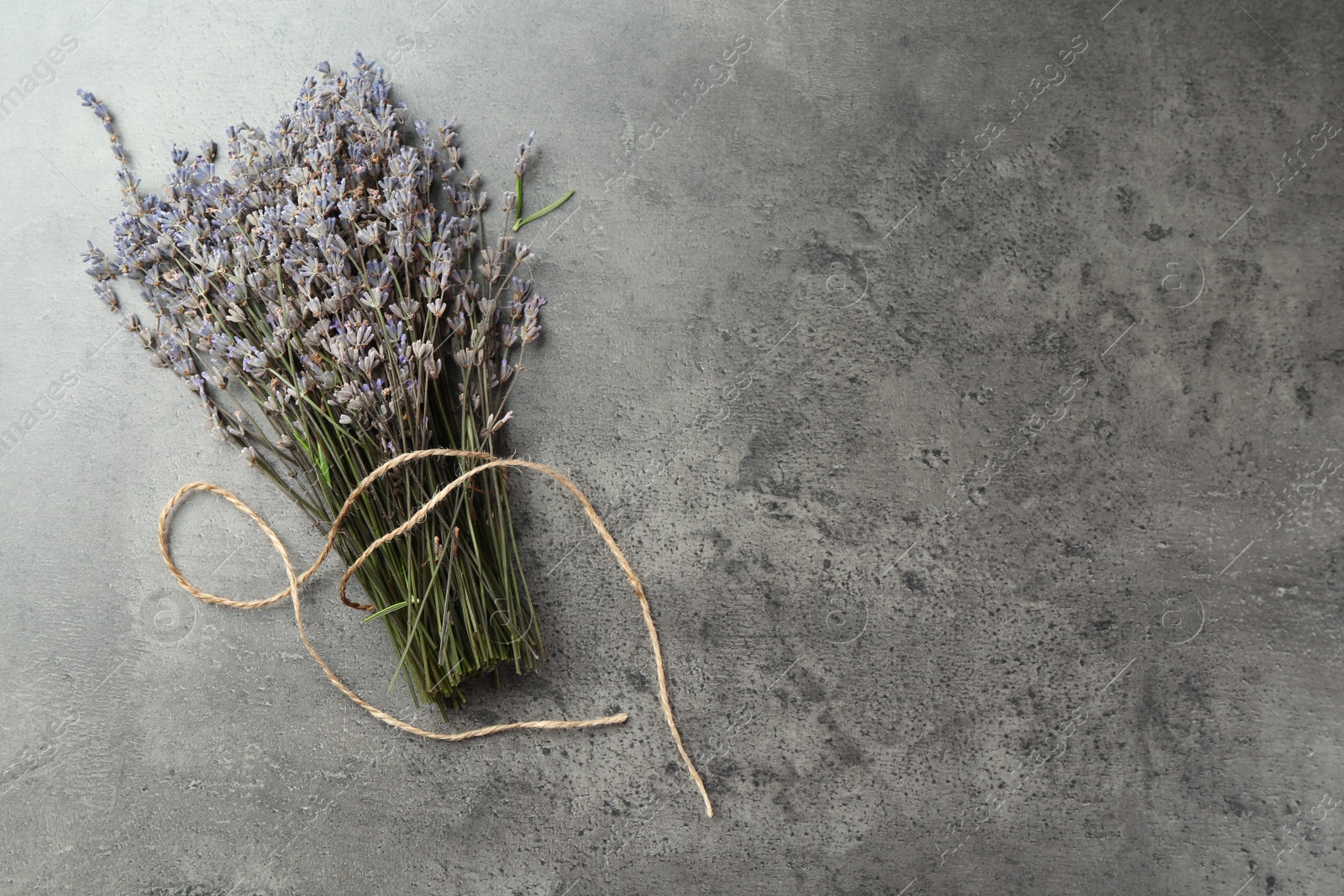 Photo of Bunch of fragrant lavender flowers on grey table, top view. Space for text
