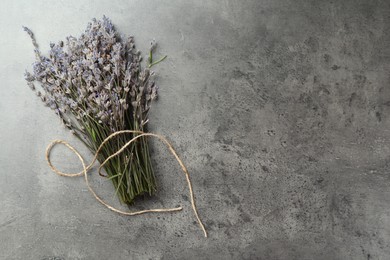 Photo of Bunch of fragrant lavender flowers on grey table, top view. Space for text