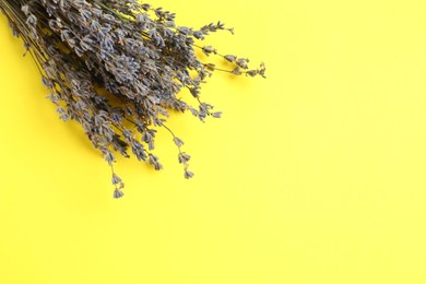 Photo of Bunch of fragrant lavender flowers on yellow background, top view. Space for text