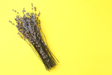 Photo of Bunch of fragrant lavender flowers on yellow background, top view. Space for text
