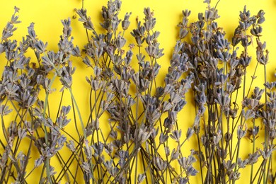 Photo of Fragrant lavender flowers on yellow background, flat lay