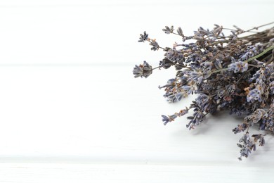 Photo of Fragrant lavender flowers on white wooden table, closeup. Space for text