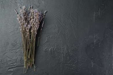 Photo of Bunch of fragrant lavender flowers on black textured table, top view. Space for text