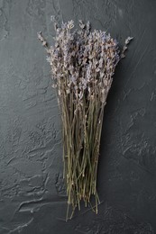 Photo of Bunch of fragrant lavender flowers on black textured table, top view