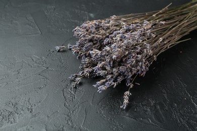 Photo of Bunch of fragrant lavender flowers on black textured table, closeup. Space for text
