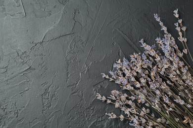 Photo of Fragrant lavender flowers on black textured table, flat lay. Space for text