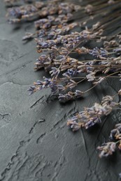 Photo of Fragrant lavender flowers on black textured table, closeup