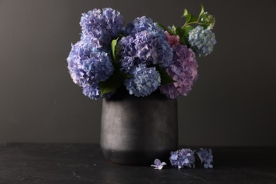 Photo of Beautiful hortensia flowers in vase on black table