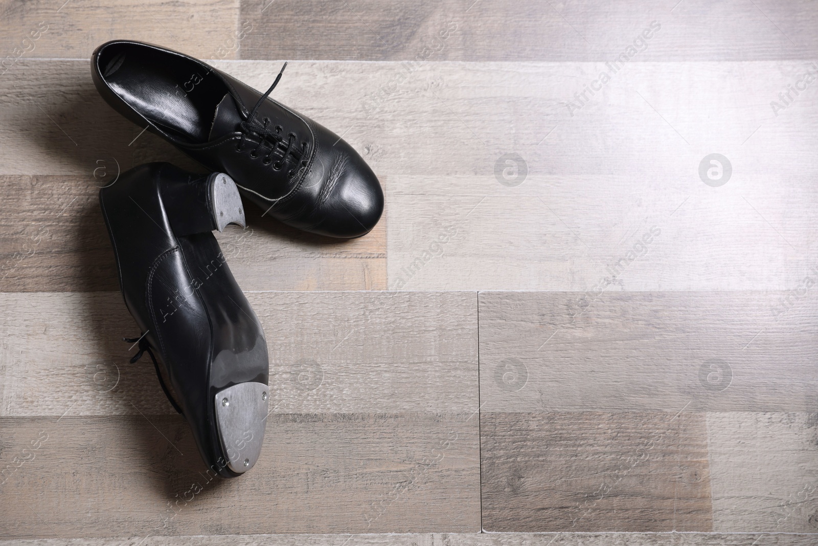 Photo of Pair of shoes for tap dance on floor, flat lay. Space for text
