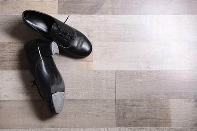 Photo of Pair of shoes for tap dance on floor, flat lay. Space for text