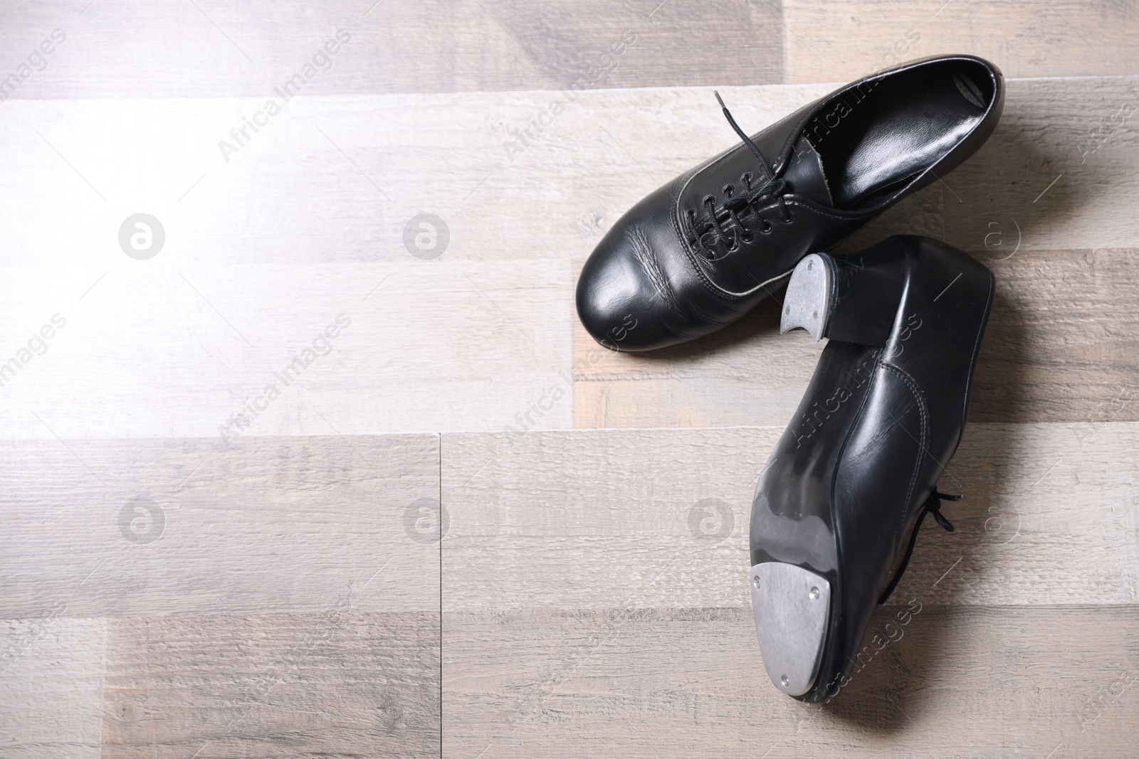 Photo of Pair of shoes for tap dance on floor, flat lay. Space for text