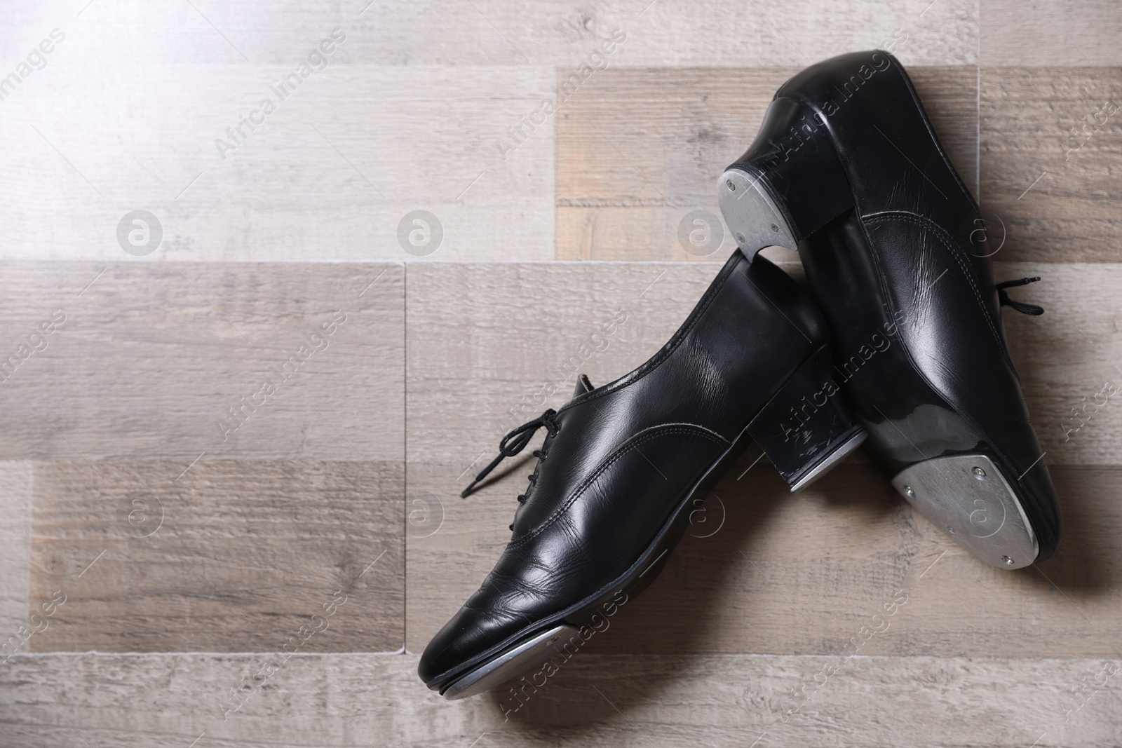 Photo of Pair of shoes for tap dance on floor, flat lay. Space for text