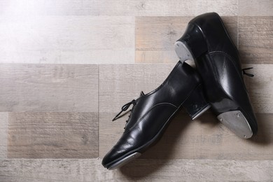 Photo of Pair of shoes for tap dance on floor, flat lay. Space for text