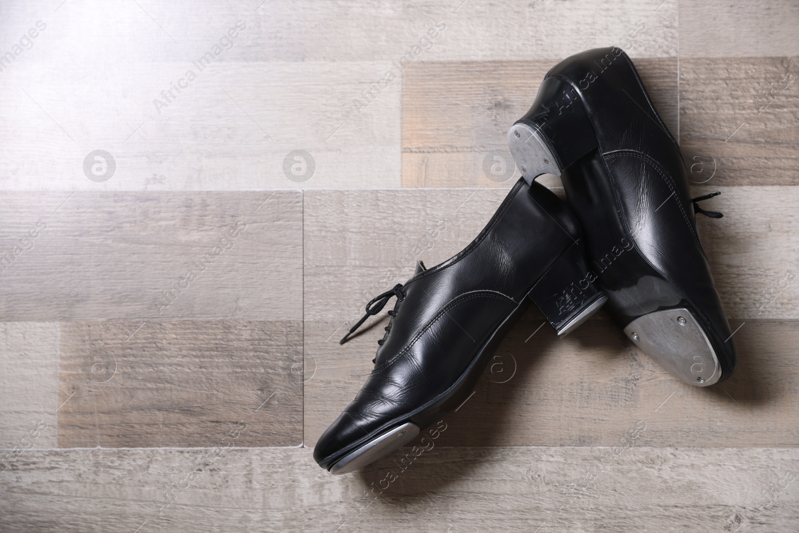 Photo of Pair of shoes for tap dance on floor, flat lay. Space for text