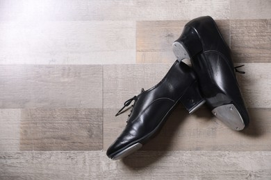 Photo of Pair of shoes for tap dance on floor, flat lay. Space for text