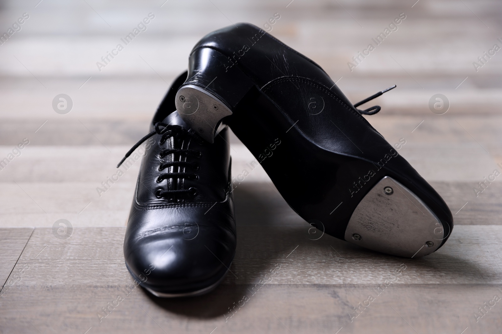 Photo of Pair of shoes for tap dance on floor, closeup