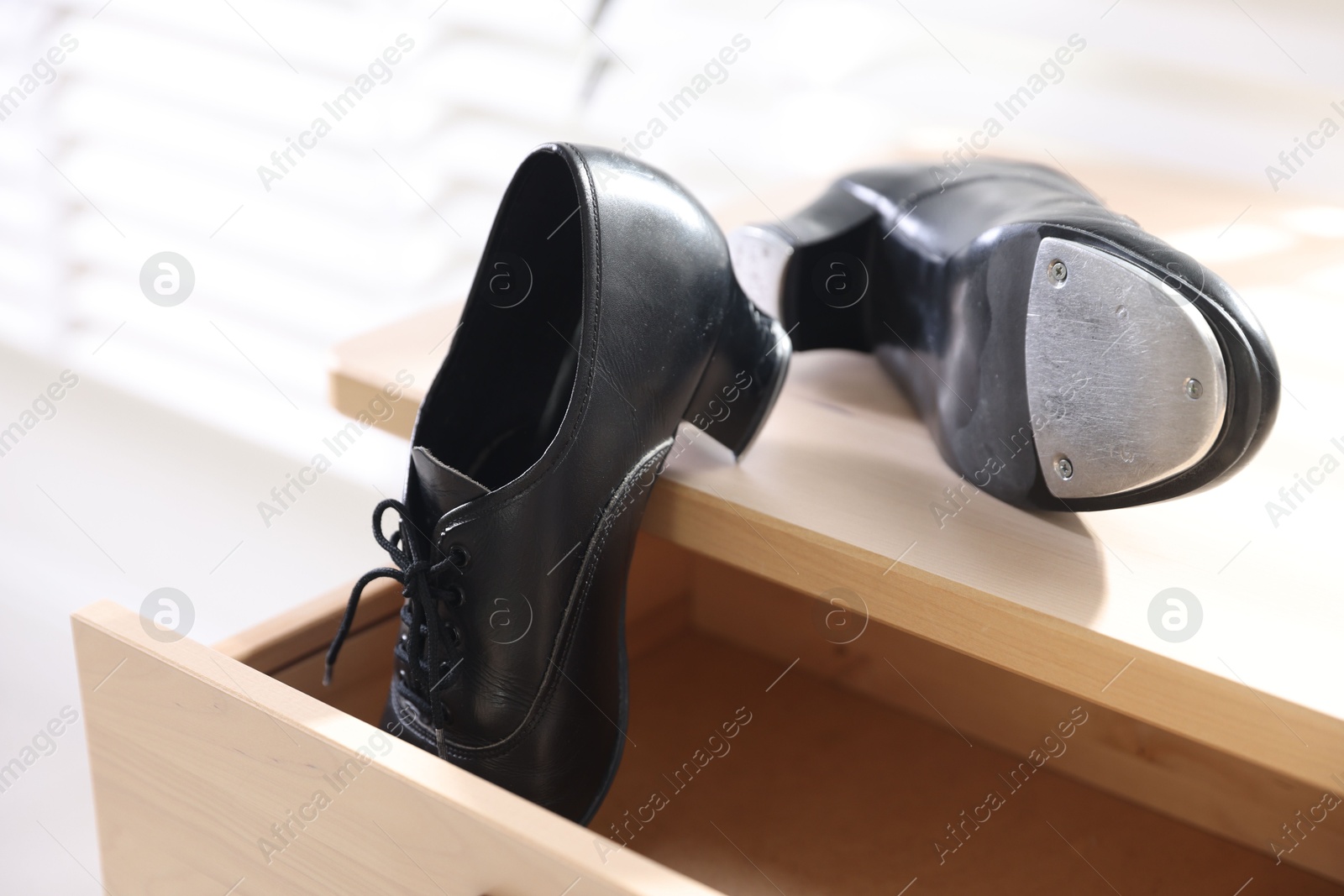 Photo of Pair of shoes for tap dance on wooden cabinet indoors, closeup