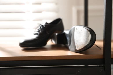 Photo of Pair of shoes for tap dance on cabinet indoors, closeup