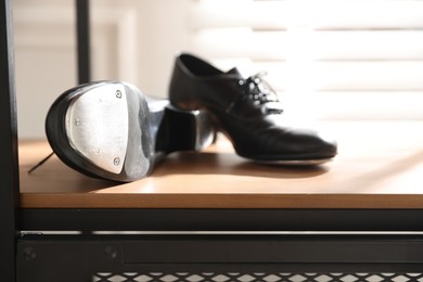 Photo of Pair of shoes for tap dance on cabinet indoors, closeup