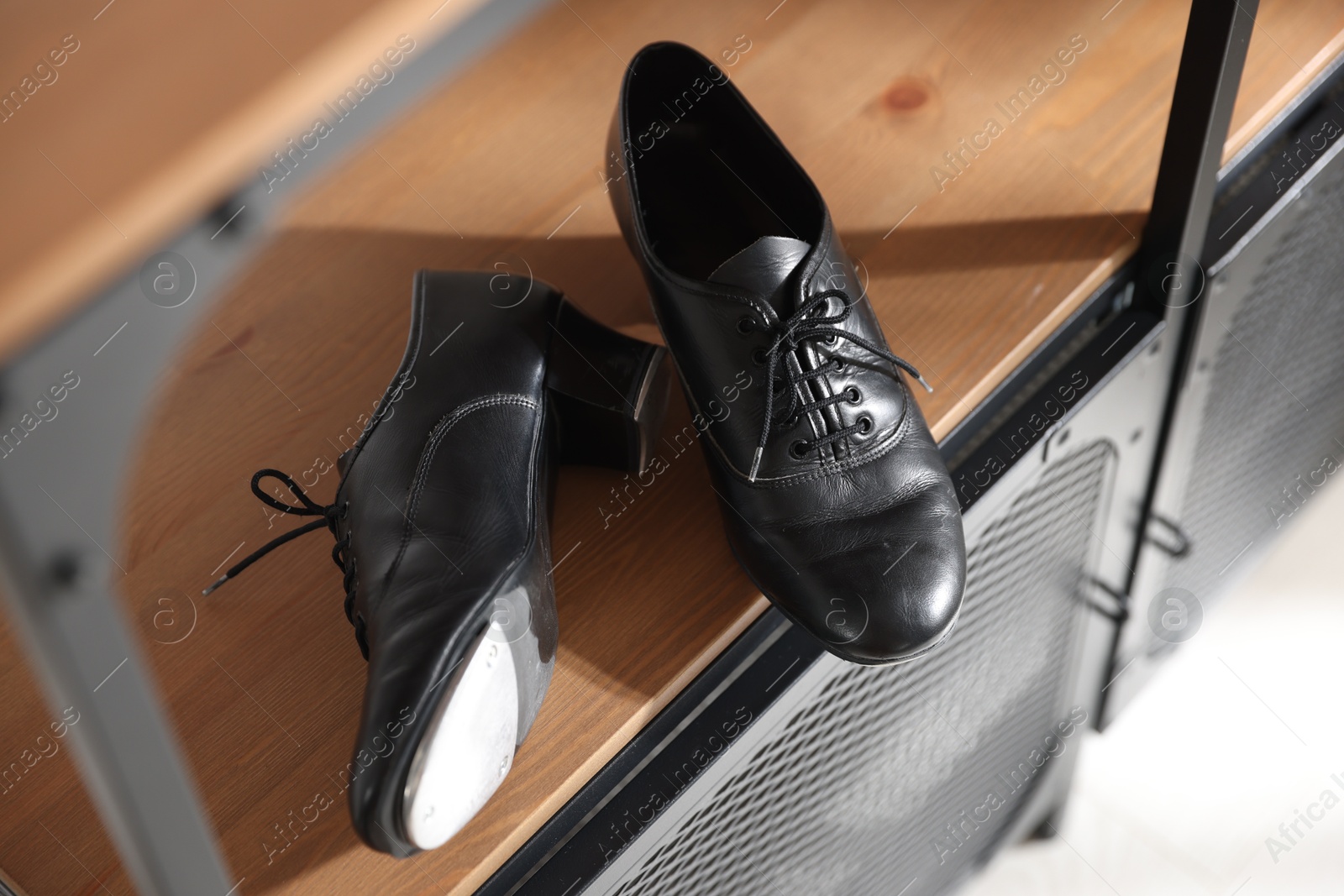 Photo of Pair of shoes for tap dance on wooden cabinet indoors, above view