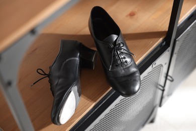 Photo of Pair of shoes for tap dance on wooden cabinet indoors, above view