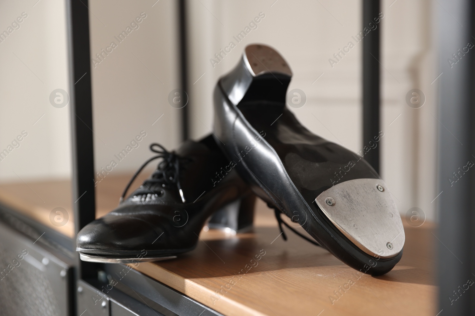 Photo of Pair of shoes for tap dance on cabinet indoors, closeup