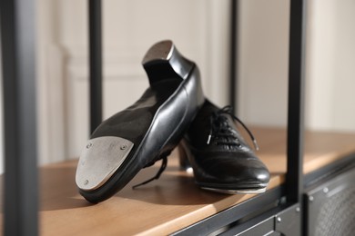 Photo of Pair of shoes for tap dance on cabinet indoors, closeup