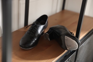 Photo of Pair of shoes for tap dance on cabinet indoors, closeup