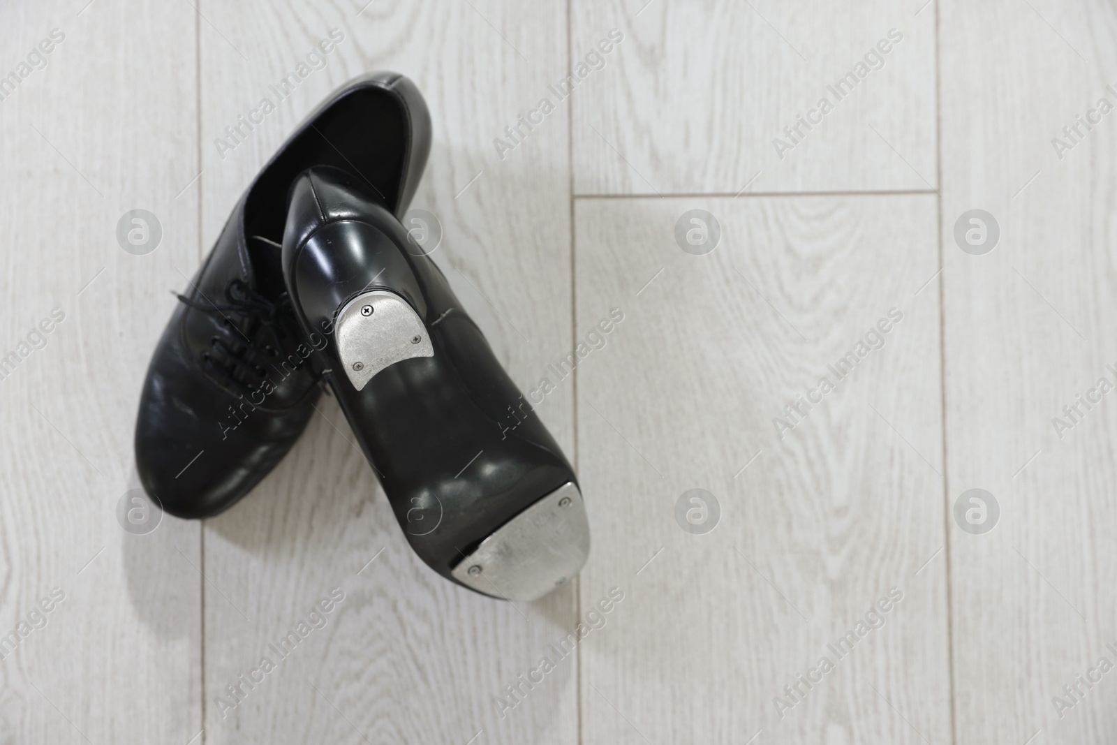 Photo of Pair of shoes for tap dance on floor, top view. Space for text
