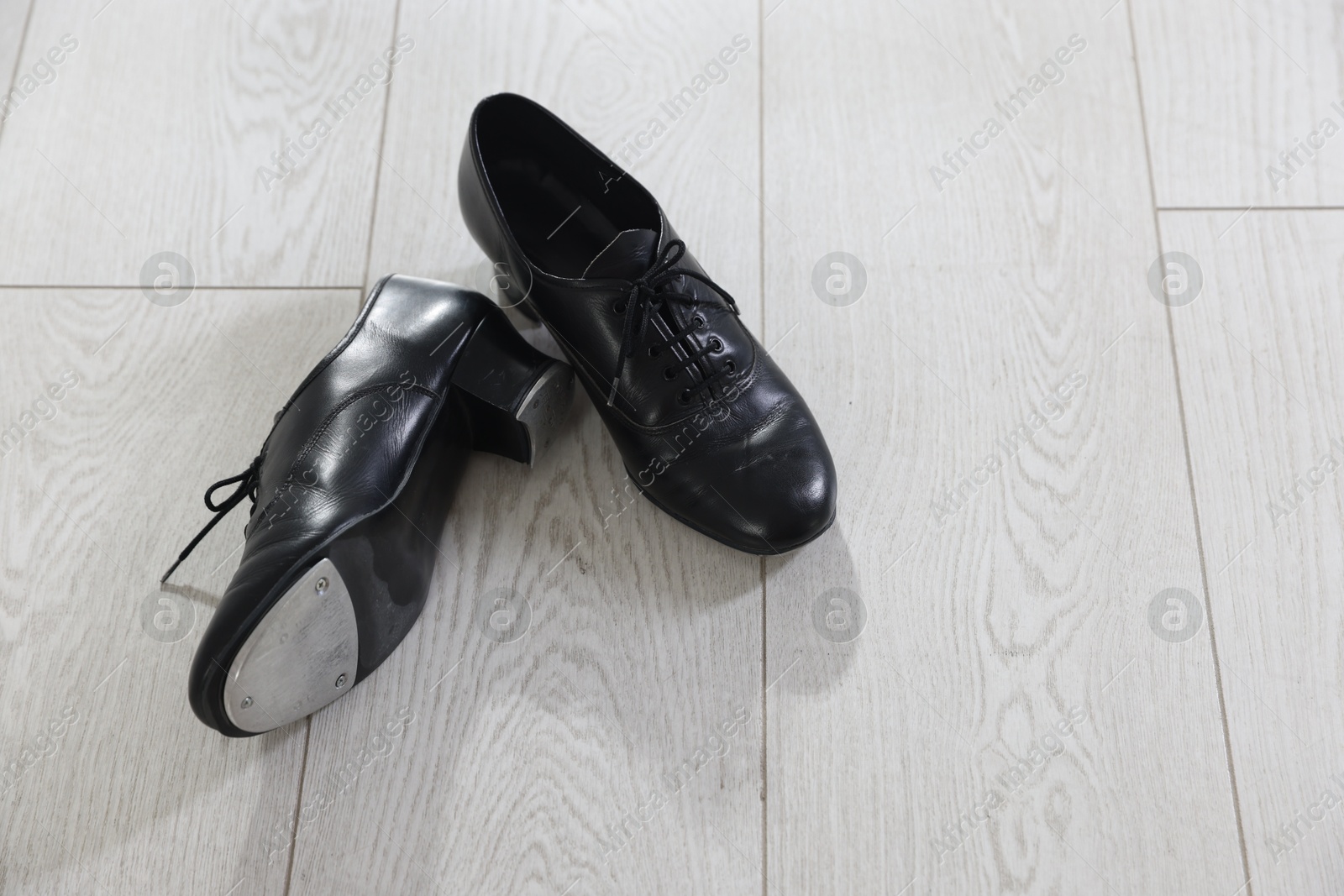 Photo of Pair of shoes for tap dance on floor, above view. Space for text