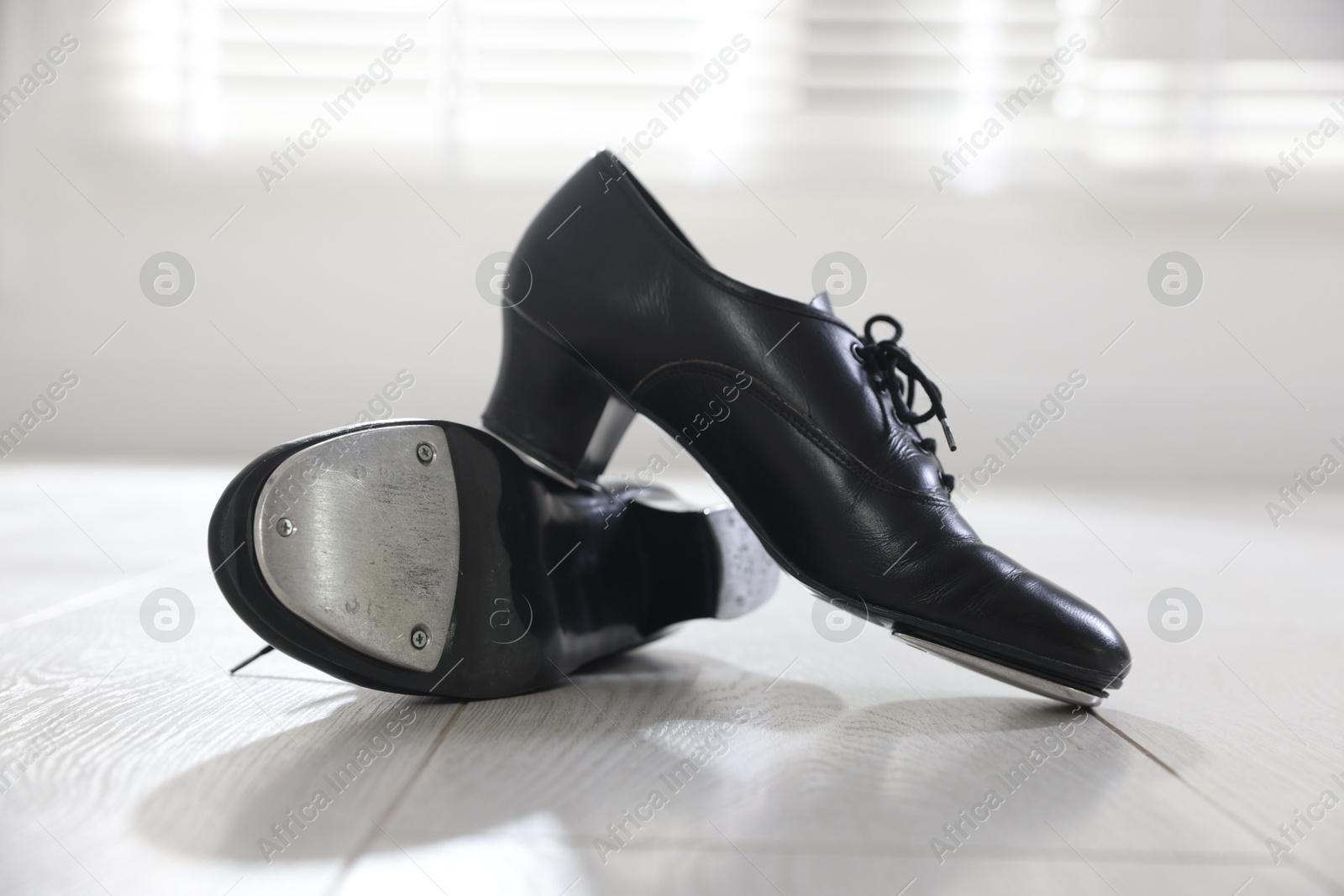 Photo of Pair of shoes for tap dance on floor indoors, closeup