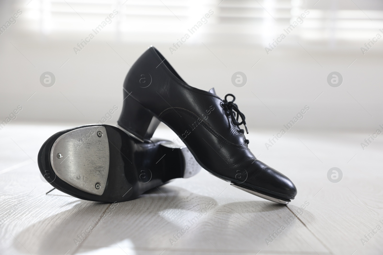 Photo of Pair of shoes for tap dance on floor indoors, closeup