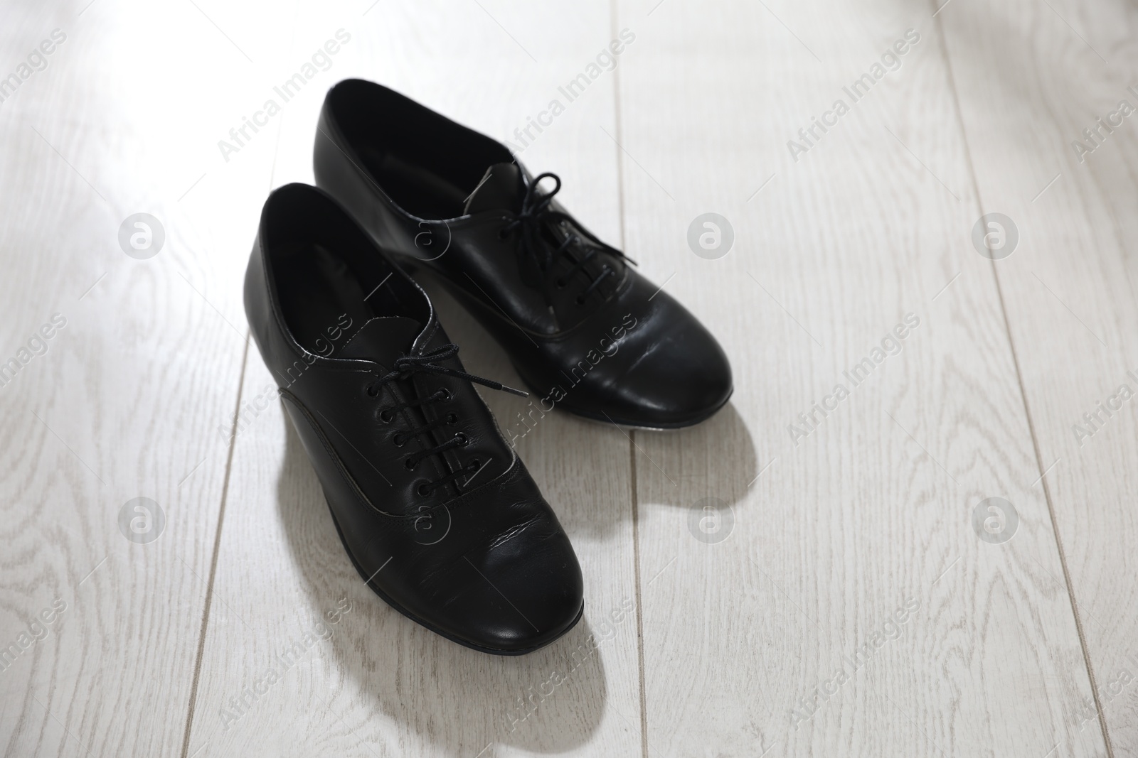 Photo of Pair of shoes for tap dance on floor indoors, above view. Space for text