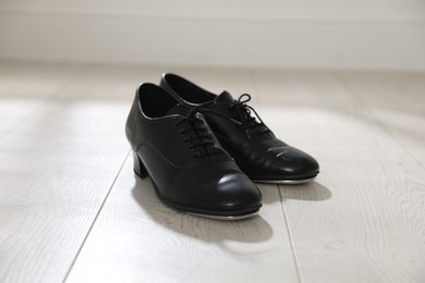 Photo of Pair of shoes for tap dance on floor indoors