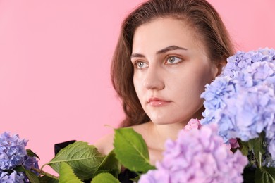 Photo of Beautiful woman with hortensia flowers on pink background