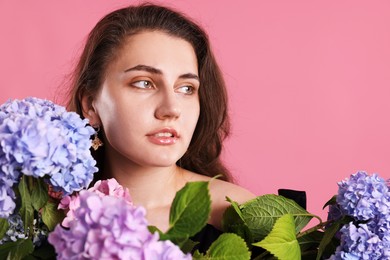 Photo of Beautiful woman with hortensia flowers on pink background