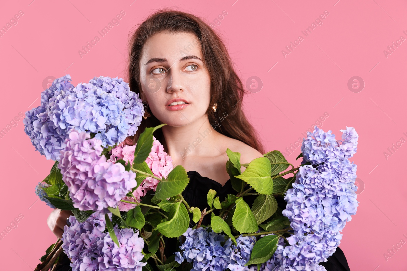 Beautiful woman with hortensia flowers on pink background Photo of Beautiful woman with hortensia flowers on pink background