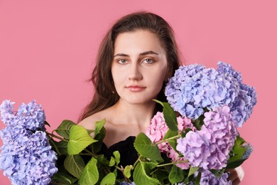 Photo of Portrait of beautiful woman with hortensia flowers on pink background