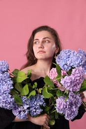 Photo of Beautiful woman with hortensia flowers on pink background