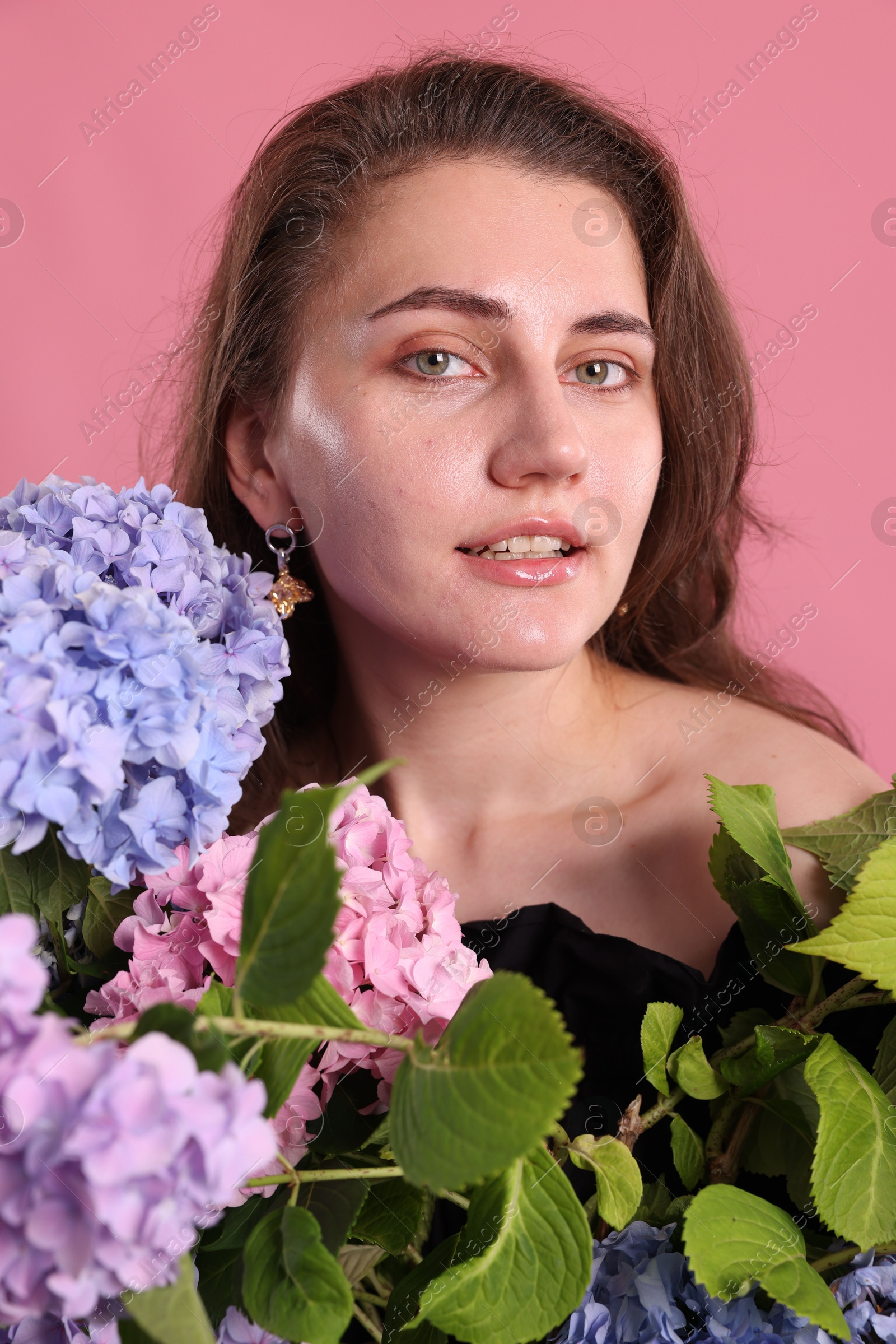 Portrait of beautiful woman with hortensia flowers on pink background Photo of Portrait of beautiful woman with hortensia flowers on pink background