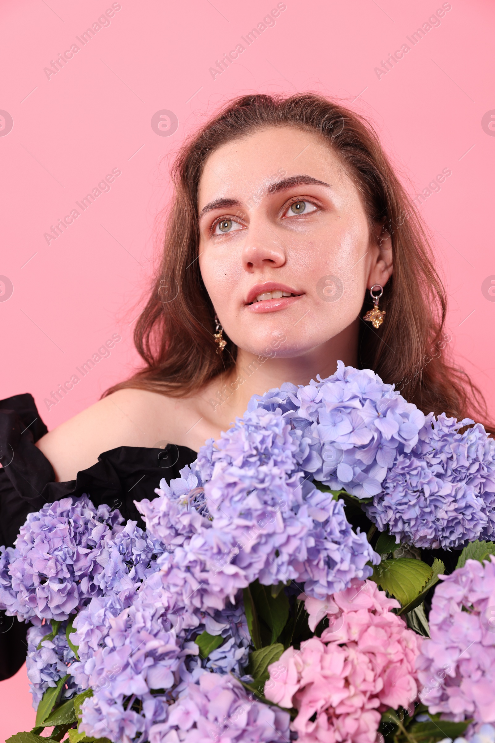 Beautiful woman with hortensia flowers on pink background Photo of Beautiful woman with hortensia flowers on pink background