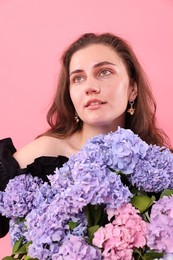 Photo of Beautiful woman with hortensia flowers on pink background