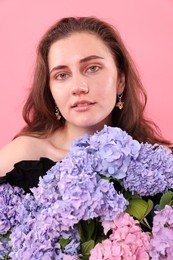 Photo of Portrait of beautiful woman with hortensia flowers on pink background