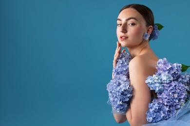 Photo of Portrait of beautiful woman with hortensia flowers on blue background. Space for text