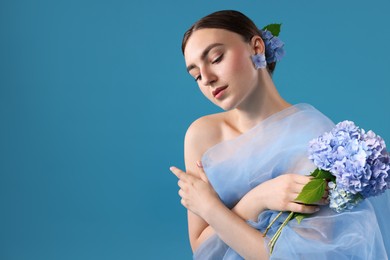 Photo of Portrait of beautiful woman with hortensia flowers and cloth on blue background. Space for text