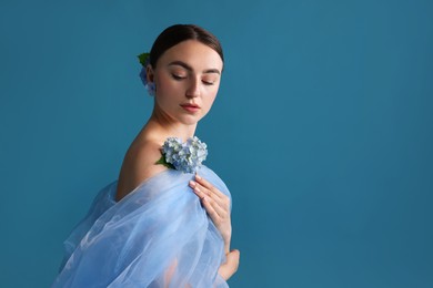 Photo of Portrait of beautiful woman with hortensia flowers and cloth on blue background. Space for text