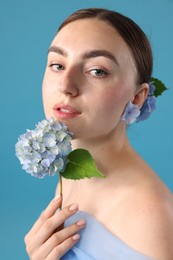 Photo of Portrait of beautiful woman with hortensia flowers on blue background